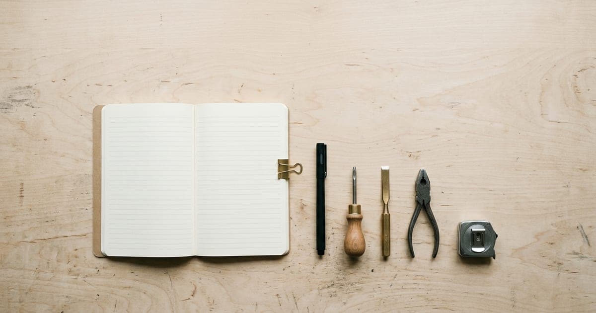 A tidy set of hand tools arranged on a pale wooden workbench